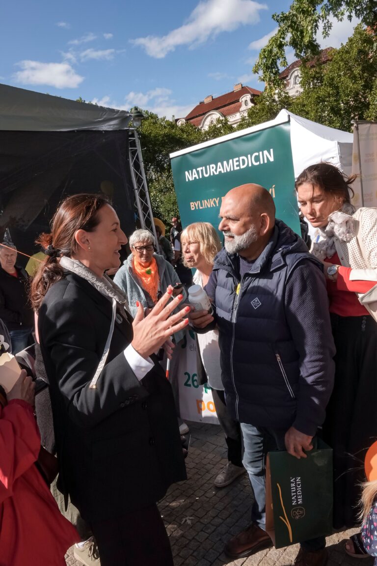 Bohuslav Větrovský při rozhovoru s návštěvnicí u banneru NATURAMEDICIN